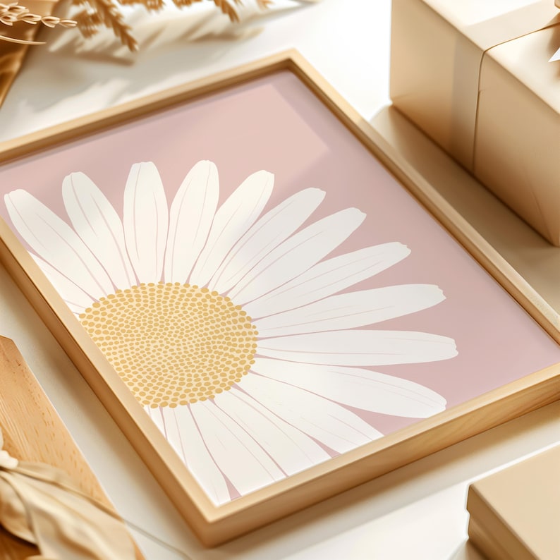 May include: A framed print of a white daisy with a yellow center on a light pink background.