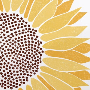 Puede incluir: Una ilustraci&oacute;n estilizada de un girasol con un centro marr&oacute;n y p&eacute;talos amarillos. Los p&eacute;talos son texturizados y tienen un aspecto descolorido.