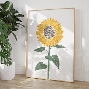 K&ouml;nnte beinhalten: Ein vertikales, rechteckiges Wandbild mit einer stilisierten Sonnenblume mit leuchtend gelben Bl&uuml;tenbl&auml;ttern und einer dunkelbraunen Mitte. Die Blume sitzt auf einem geraden gr&uuml;nen Stiel mit zwei gr&uuml;nen Bl&auml;ttern vor einem wei&szlig;en Hintergrund.
