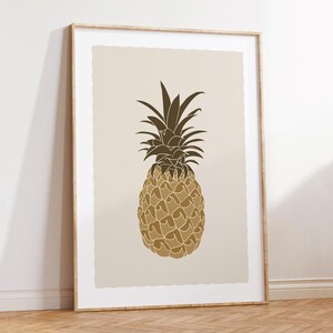 Peut inclure: Impression d'art encadrée représentant une illustration stylisée d'ananas. L'ananas est représenté dans des tons bruns et dorés sur un fond neutre. L'œuvre est présentée dans un cadre en bois, ajoutant une touche chaleureuse au thème tropical.