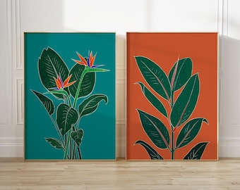 May include: Two framed prints of tropical plants. The print on the left features a green background with a bird of paradise flower in orange, blue, and red. The print on the right features an orange background with a green plant.