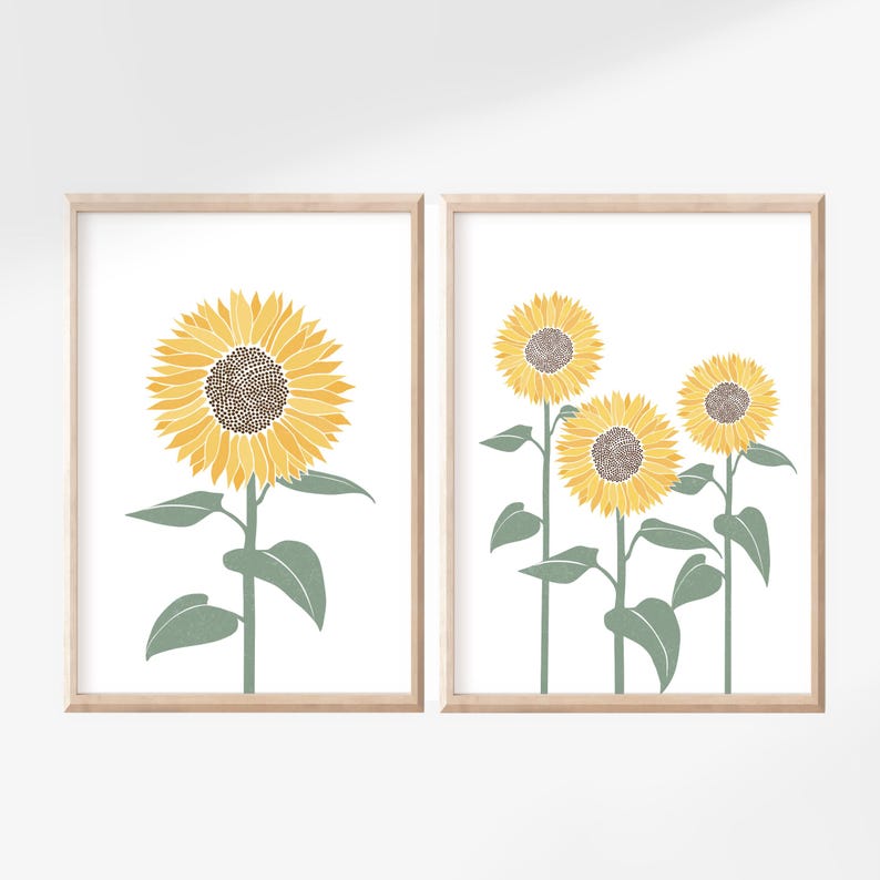 K&ouml;nnte beinhalten: Zwei gerahmte Wandbilder mit Sonnenblumenillustrationen. Das linke Bild zeigt eine einzelne gro&szlig;e Sonnenblume mit gelben Bl&uuml;tenbl&auml;ttern und brauner Mitte. Das rechte Bild zeigt drei Sonnenblumen unterschiedlicher H&ouml;he mit gr&uuml;nen Stielen und Bl&auml;ttern.