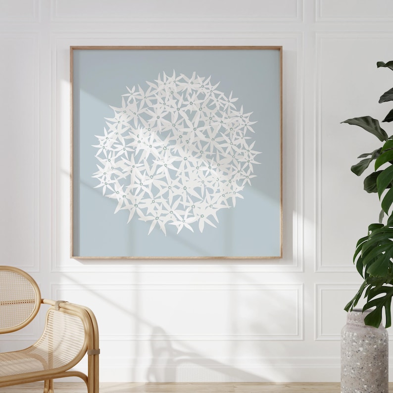 May include: A framed print of a white floral design on a light blue background. The floral design is a cluster of white flowers in a circular shape.