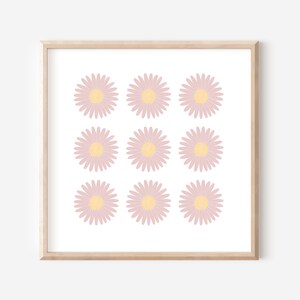 May include: A framed print with a pattern of nine pink and yellow daisies on a white background.