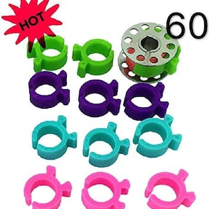 May include: A set of 60 colorful plastic thread bobbin holders in green, purple, blue, and pink. The bobbin holders are designed to fit around a standard sewing machine bobbin. The set also includes a metal bobbin winder.
