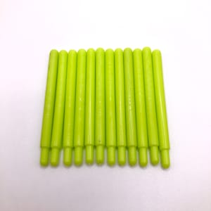 May include: A set of 15 lime green plastic rods, all the same size, arranged in a row.