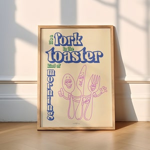 Könnte beinhalten: Ein beiger Poster mit blauem und grünem Text, der "Es ist eine Gabel im Toaster, so eine Art Morgen" lautet. Der Poster zeigt eine Cartoon-Illustration einer Gabel und eines Löffels mit lächelnden Gesichtern.