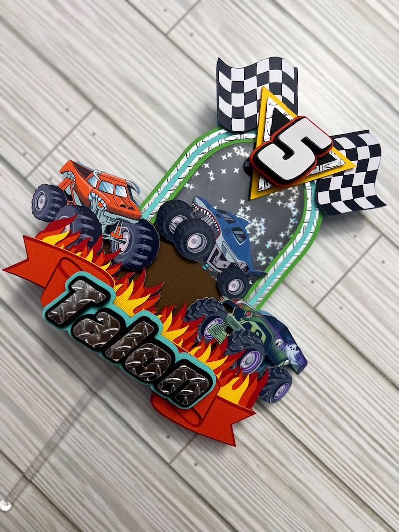 May include: A colorful birthday card featuring three monster trucks racing on a track. The card includes the name "Talen" in a textured font, flames, checkered flags, and the number "5".