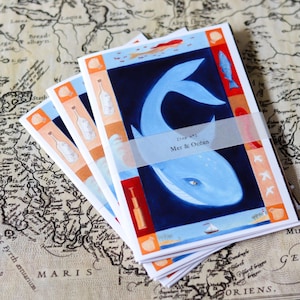 Peut inclure: Plusieurs impressions d'art avec une illustration de baleine bleue sur fond bleu foncé. Les impressions ont une bande blanche avec le texte "Mer & Ocean". Les bordures sont orange, rouge et bleu. Les impressions sont sur une carte vintage.