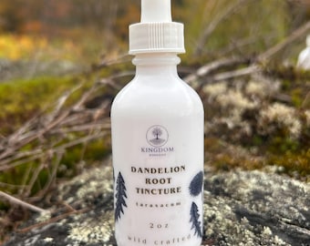 May include: A white glass dropper bottle containing dandelion root tincture. The label features the text Kingdom Remedies, Dandelion Root Tincture, taraxacum, 2 oz, and wild crafted, along with black illustrations of dandelion plants.