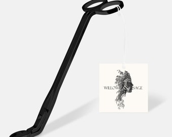 Op de afbeelding: Zwarte metalen kaarsendoornknipper met een lange handgreep en een lus aan de bovenkant. De knipper hangt aan een wit label met de tekst "WILLOW & SAGE" en een zwart-witte illustratie van een vrouwenhoofd met bladeren.