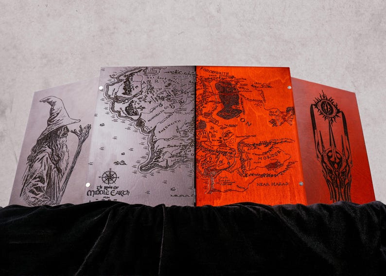 May include: A four-panel folding screen featuring laser-engraved illustrations. The left panel shows a wizard, the second displays a map of Middle-earth, the third depicts a map of Mordor, and the right panel features a dark tower with an eye.