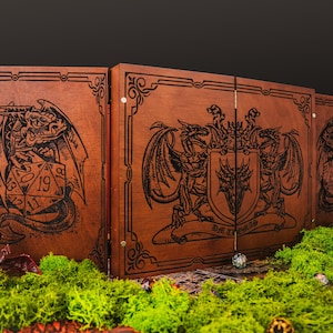 May include: A wooden tabletop gaming screen with intricate dragon and shield designs. The screen is brown with black etched artwork and features a D20 die. The screen is set on a bed of green moss.