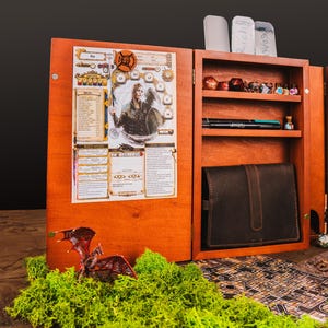 Peut inclure: Organisateur de jeu de soci&eacute;t&eacute; en bois avec plusieurs compartiments. Comprend une fiche de personnage, des d&eacute;s, des stylos et un &eacute;tui en cuir. Inclut une figurine de dragon miniature et une carte.