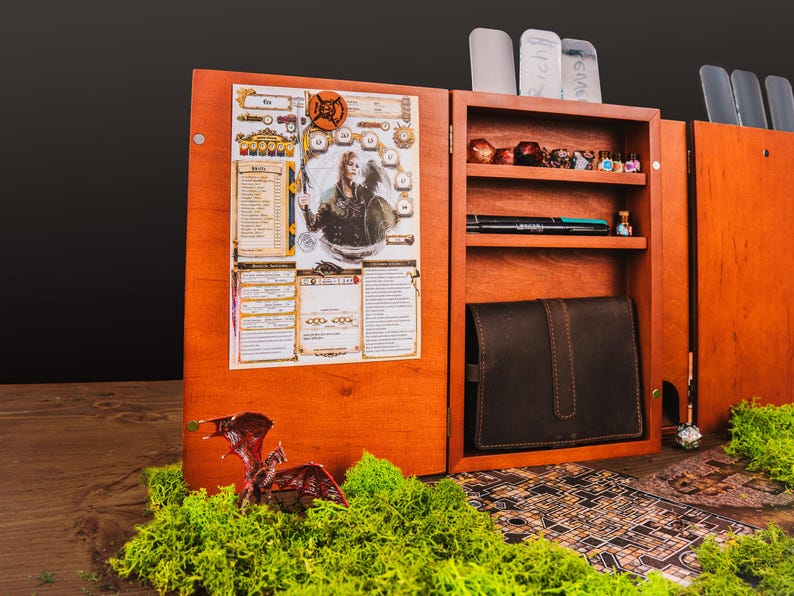 Peut inclure: Organisateur de jeu de soci&eacute;t&eacute; en bois avec plusieurs compartiments. Comprend une fiche de personnage, des d&eacute;s, des stylos et un &eacute;tui en cuir. Inclut une figurine de dragon miniature et une carte.