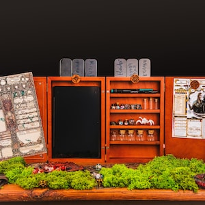 May include: A wooden tabletop gaming organizer with multiple compartments. It features a large character sheet, a black dry-erase board, shelves with dice, vials, and a white spider figurine. The organizer is decorated with moss and small details.