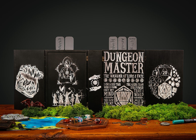 Peut inclure: Un &eacute;cran de ma&icirc;tre de donjon en bois noir avec des illustrations et du texte blancs. L'&eacute;cran pr&eacute;sente diverses images sur le th&egrave;me de la fantaisie et le texte "Dungeon Master". Des d&eacute;s, un plateau de jeu et d'autres accessoires de jeu sont devant l'&eacute;cran.