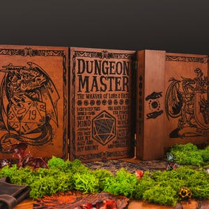 May include: A brown wooden Dungeon Master screen, featuring engraved dragon and dice designs. The central panel displays the text "DUNGEON MASTER". The screen is set on a wooden table, adorned with green moss.