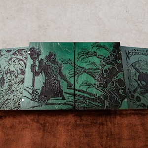 May include: Four rectangular green wooden panels featuring black laser-engraved illustrations. The designs include a large skull, a robed figure holding a staff, skeletal hands, and a circular emblem with a skull and the text Book of Necromancy.