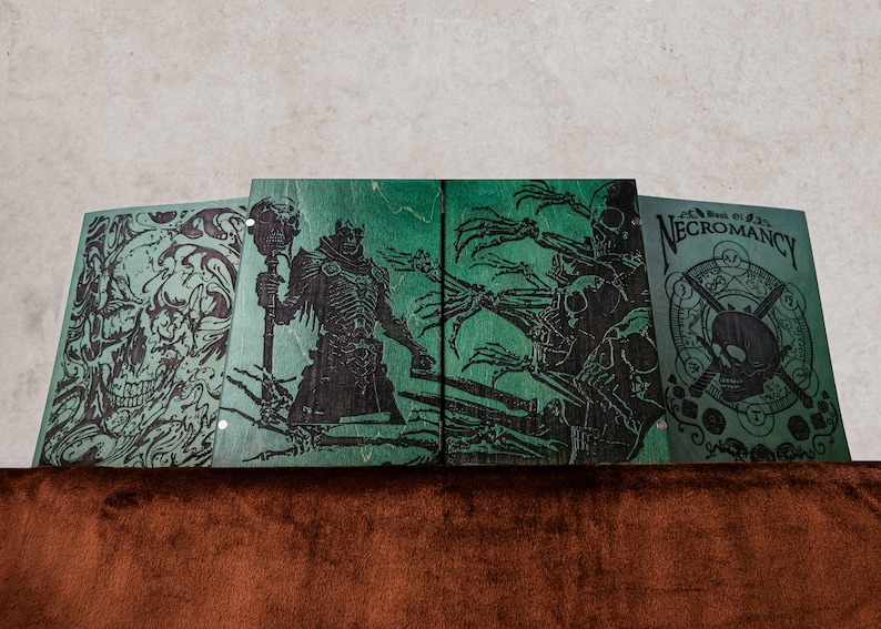 May include: Four rectangular green wooden panels featuring black laser-engraved illustrations. The designs include a large skull, a robed figure holding a staff, skeletal hands, and a circular emblem with a skull and the text Book of Necromancy.