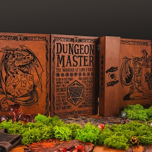 Peut inclure: &Eacute;cran de ma&icirc;tre de donjon en bois marron, avec des illustrations grav&eacute;es de dragons et de d&eacute;s. Le panneau central affiche le texte "DUNGEON MASTER". L'&eacute;cran est pos&eacute; sur une table en bois, orn&eacute;e de mousse verte.