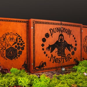 May include: A wooden Dungeon Master screen with a dark orange finish. The screen features engraved dice and dragon designs, along with the words "Dungeon Master." The screen is set against a dark background with green moss.