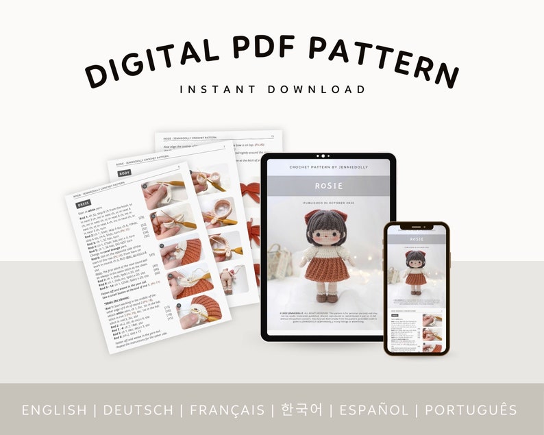 May include: Digital PDF crochet pattern for a doll named Rosie. The pattern includes instructions in English, German, French, Korean, Spanish, and Portuguese. The image shows a crocheted doll with brown hair and a red dress, along with a digital tablet and a smartphone displaying the pattern.