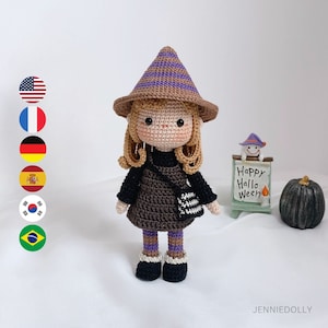 Pode incluir: Uma boneca de bruxa de crochê com cabelo castanho, um chapéu pontudo roxo e marrom, um vestido marrom e leggings listradas marrom e roxo. A boneca está segurando uma bolsa marrom e branca.