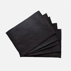 May include: A stack of six black felt squares, folded in a fan shape.