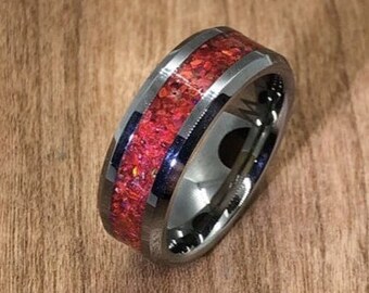 以下が含まれることがあります： 赤と黒のインレイが施された銀色のタングステンカーバイドリング。リングは面取りされたエッジと磨かれた仕上げになっています。