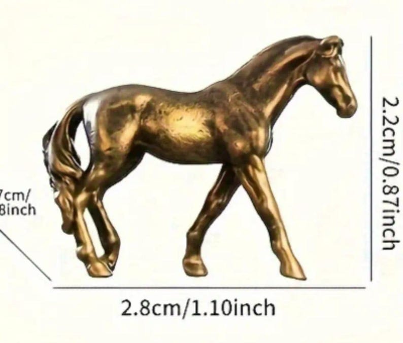 Puede incluir: Figura de caballo de color bronce, de 2,8 cm de largo y 2,2 cm de alto. La escultura representa un caballo en movimiento. La figura tiene una melena y cola detalladas. Objeto decorativo.