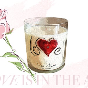 Candle gift set: a black sleek gift set adorned with a red ribbon. Love candle adorned with a clear label. Beneath, a black and white box. A white tip 4in matchstick in a glass vial