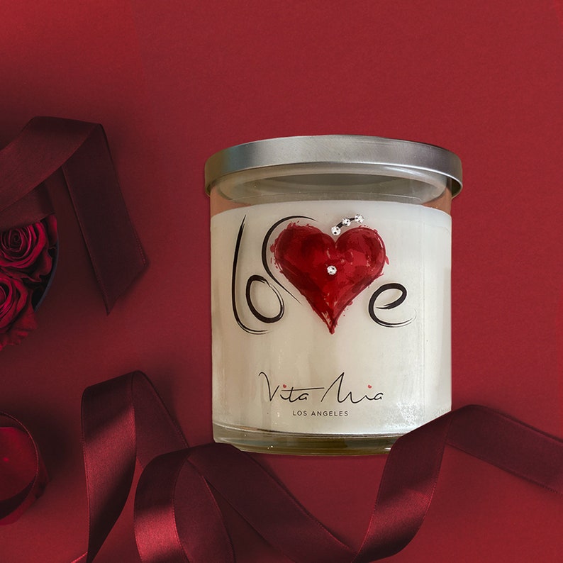Candle gift set: a black sleek gift set adorned with a red ribbon. Love candle adorned with a clear label. Beneath, a black and white box. A white tip 4in matchstick in a glass vial