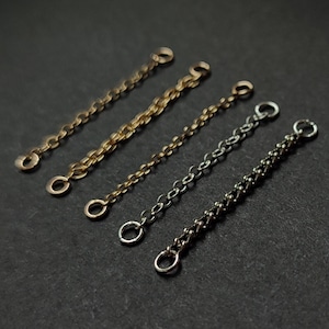 May include: Four different chain extenders, two gold, one silver, and one black, with jump rings at each end.