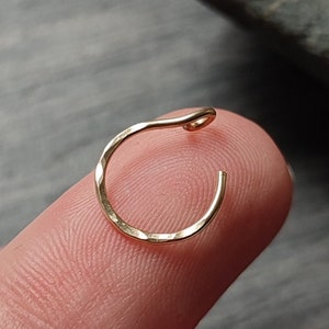 May include: Two gold nose rings with a hammered finish. The rings are small and delicate, and they are perfect for adding a touch of style to any look.