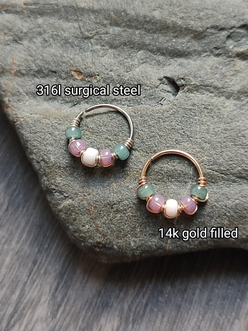 May include: Two hoop earrings with a row of pastel green, pink, and white beads. The hoop on the left is made of 316L surgical steel, and the hoop on the right is made of 14k gold filled.