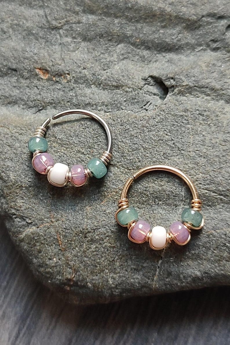 May include: Two silver and gold hoop earrings with green, pink, and white beads.
