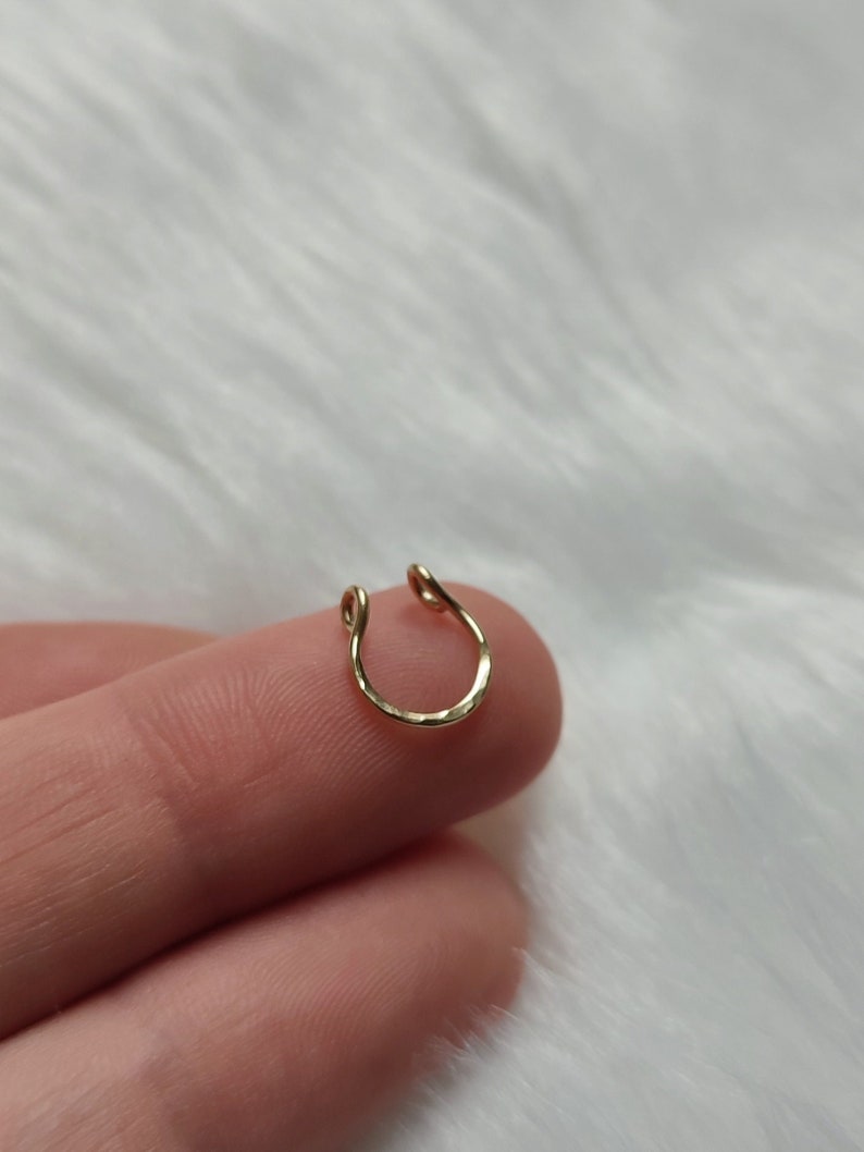 A dainty gold filled fake septum ring, with a shimmery, lightly hammered texture that reflects the light beautifully