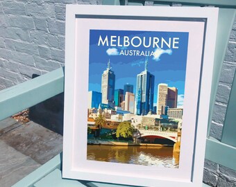 May include: A white framed print with a colorful illustration of the Melbourne skyline. The print features the text "MELBOURNE" and "AUSTRALIA" in white letters.