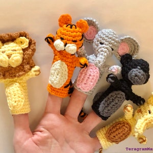 Könnte beinhalten: Satz mit fünf Fingerpuppen, die verschiedene Tiere darstellen: ein Löwe, ein Tiger, ein Elefant, ein Affe und eine Giraffe. Die Puppen sind in verschiedenen Farben gehäkelt, darunter Gelb, Orange, Braun, Grau und Schwarz.
