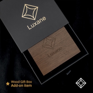 Peut inclure: Une bo&icirc;te cadeau noire avec un logo dor&eacute; et le nom "Luxane" imprim&eacute; sur le couvercle. &Agrave; l'int&eacute;rieur, une carte en bois avec le m&ecirc;me logo et nom est visible. Le texte "Wood Gift Box Add-on item" est &eacute;galement pr&eacute;sent.