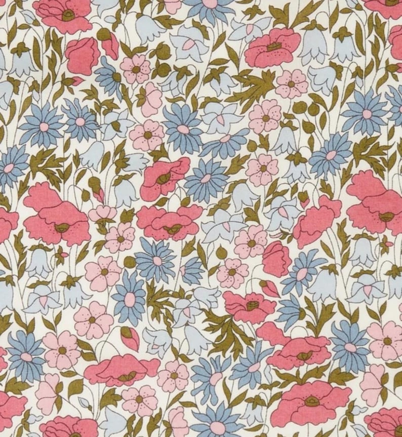 Op de afbeelding: Een bloemenpatroon met roze klaprozen, lichtblauwe madeliefjes en klokvormige bloemen op een cr&egrave;mekleurige achtergrond. Het ontwerp bevat groene stelen en bladeren, waardoor een delicate en kleurrijke botanische print ontstaat.