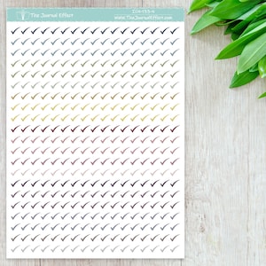 Pode incluir: Uma folha de 100 adesivos de marca de verifica&ccedil;&atilde;o coloridos em v&aacute;rios tons de azul, verde, amarelo, vermelho e preto. Os adesivos est&atilde;o dispostos em linhas e colunas sobre um fundo branco. O texto "The Journal Effect" e "ICN-133-N" est&aacute; impresso na parte superior da folha.