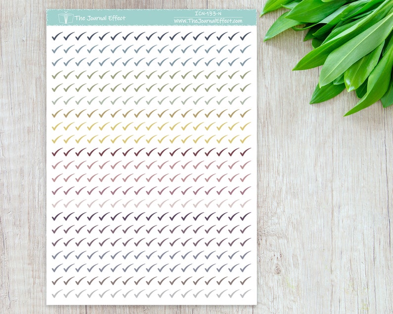 Pode incluir: Uma folha de 100 adesivos de marca de verifica&ccedil;&atilde;o coloridos em v&aacute;rios tons de azul, verde, amarelo, vermelho e preto. Os adesivos est&atilde;o dispostos em linhas e colunas sobre um fundo branco. O texto "The Journal Effect" e "ICN-133-N" est&aacute; impresso na parte superior da folha.