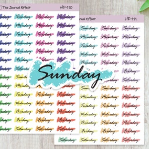 May include: A sheet of colorful stickers with the days of the week written on them. The stickers are in a rainbow of colors, including pink, orange, yellow, green, blue, and purple. The stickers are designed to be used in a planner or journal.