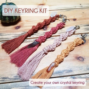 May include: DIY Keyring Kit featuring three macrame keyrings in different colours, each with a crystal attached. Each keyring has a tassel and a metal ring. The text "Create your own crystal keyring" is at the bottom of the image.