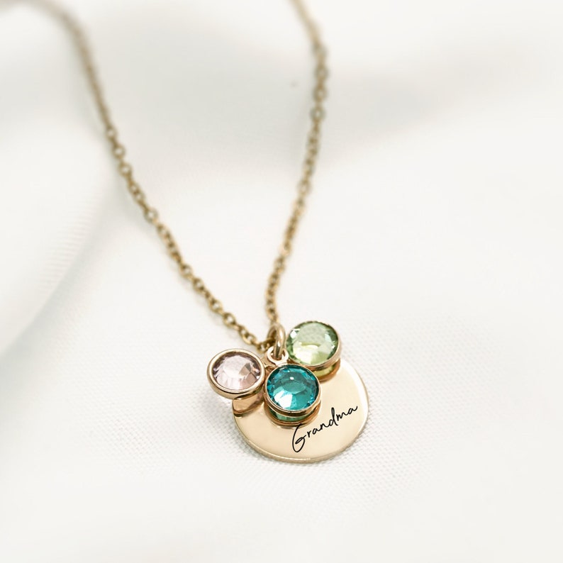 gold necklace that says “grandma” with three gemstones.