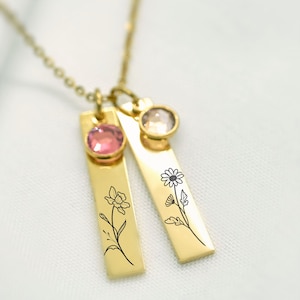 Gold birth flower necklace with engraved floral designs and personalized birthstone charms. A meaningful and elegant jewelry piece representing birth months and loved ones. Perfect sentimental gift for mothers, grandmothers, or special occasions like birthdays and anniversaries.