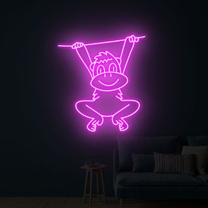 May include: A neon pink sign of a cartoon monkey hanging from a branch. The monkey is smiling and has its arms outstretched.