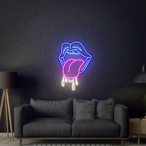 May include: A neon sign shaped like a pair of lips with a tongue sticking out. The lips are outlined in blue, the tongue is pink, and the dripping saliva is yellow. The sign is mounted on a dark wall above a gray sofa.